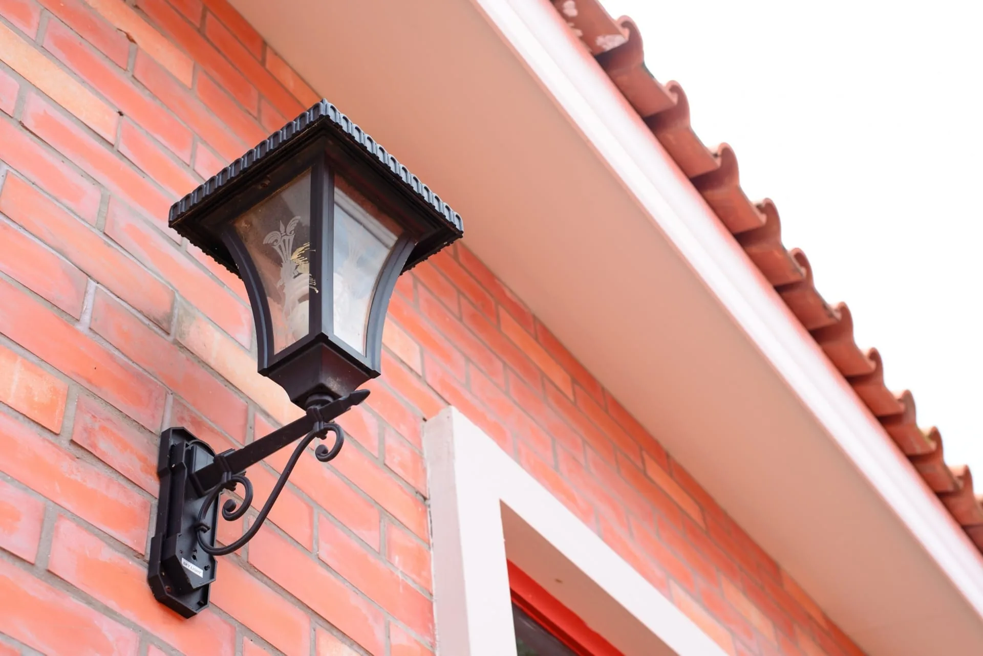 Motion-sensor floodlight mounted near a home entrance
